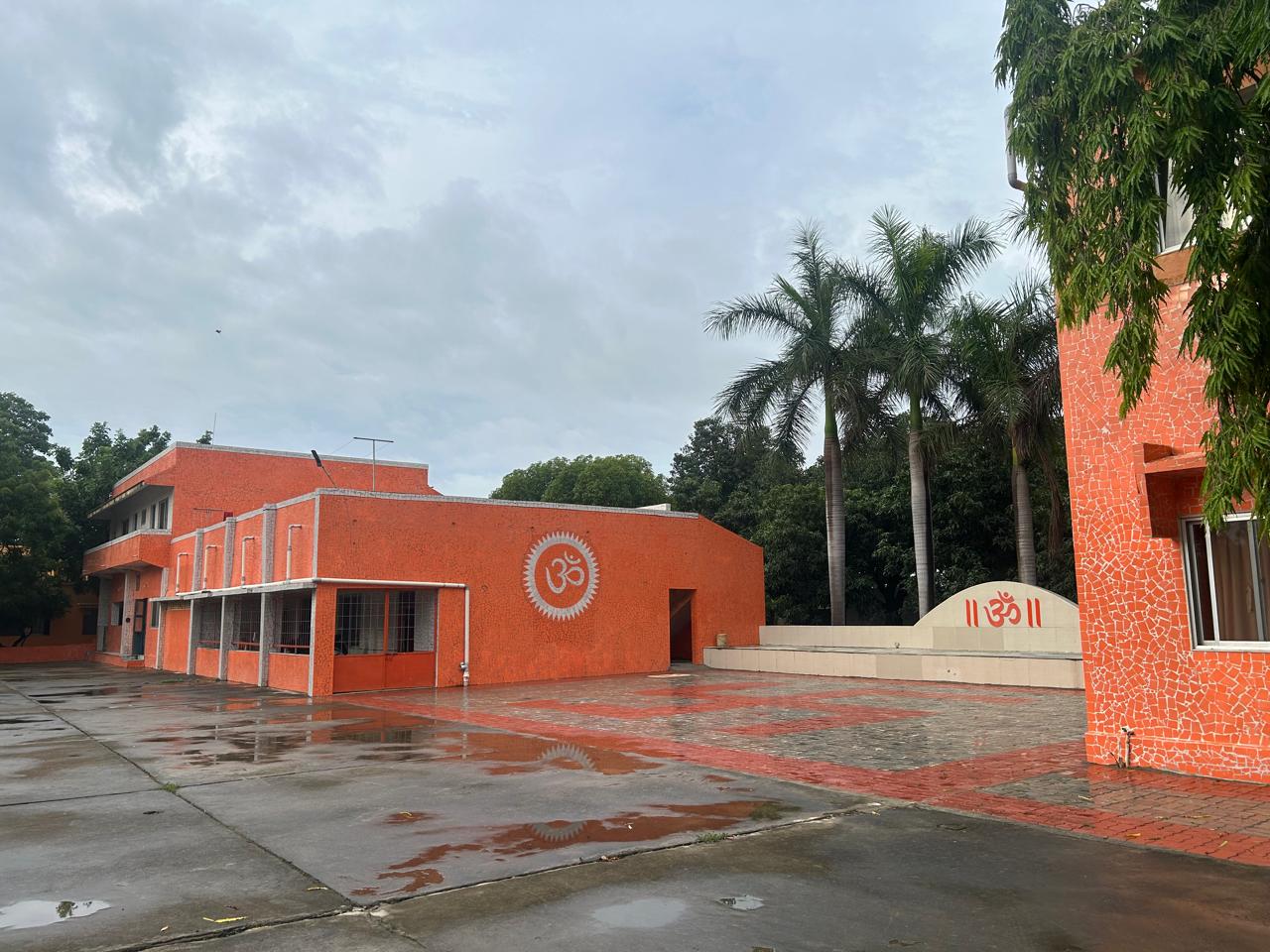 Exterior view of Nirvandham Yogashram with Om symbol