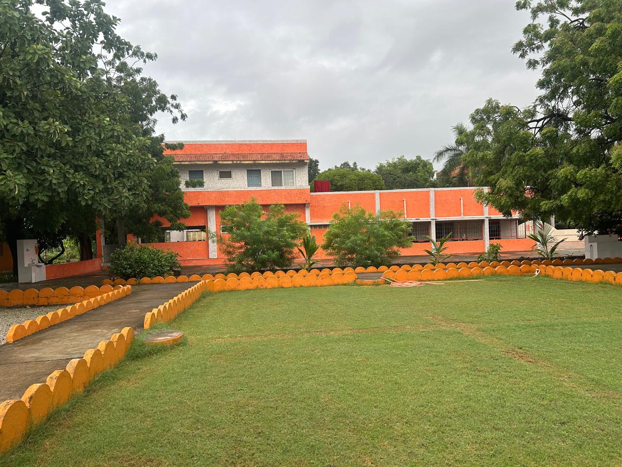 Lush green lawn and ashram buildings